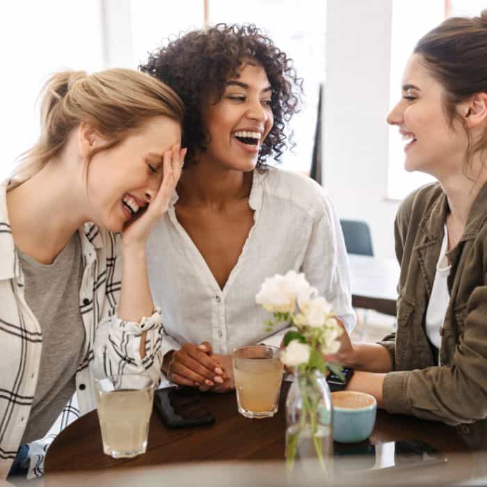 A group of women sitting together laughing and talking.