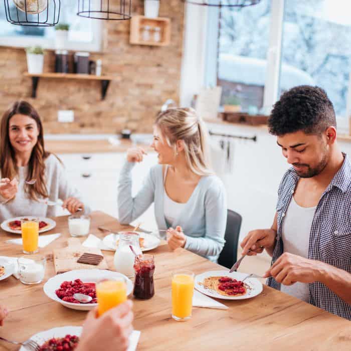 A group of friends eating breakfast food together.